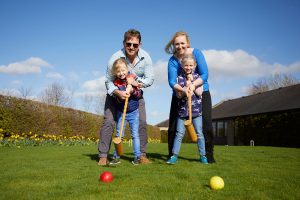 Family playing croquet Slider1